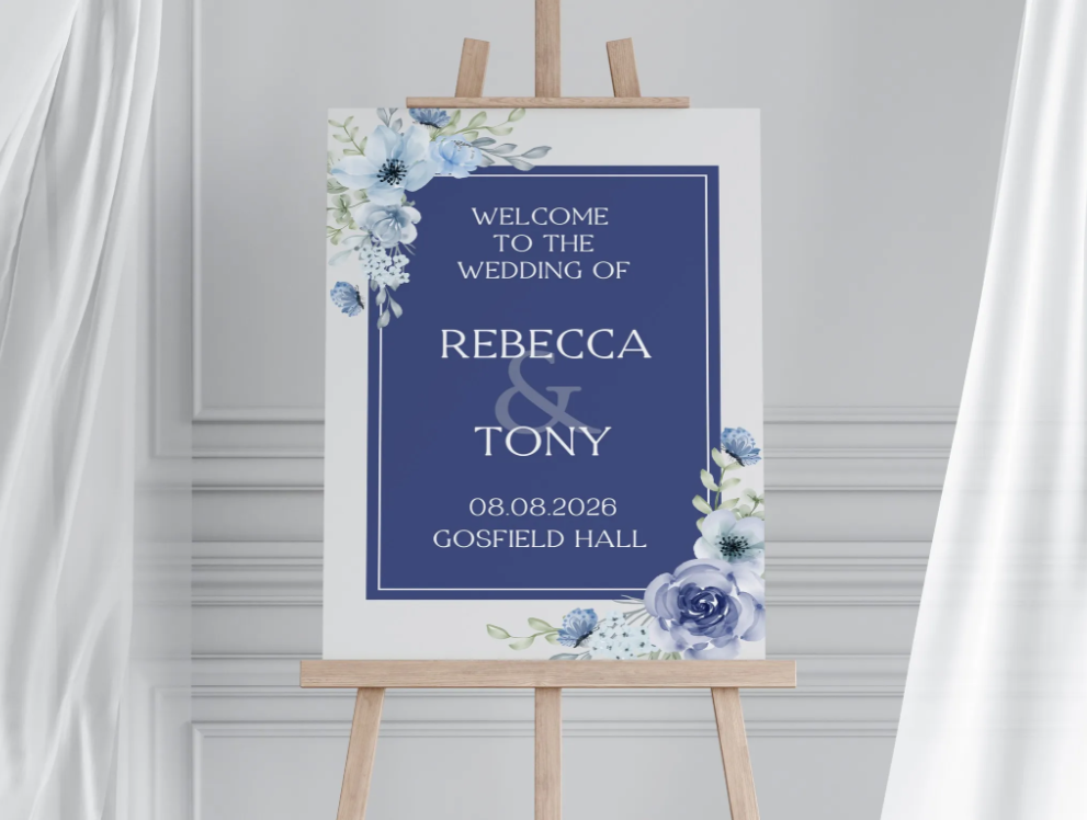 Wedding reception welcome sign with navy blue floral design on an easel