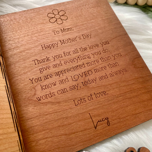 Wooden card with engraved message for Mother's Day on a white surface