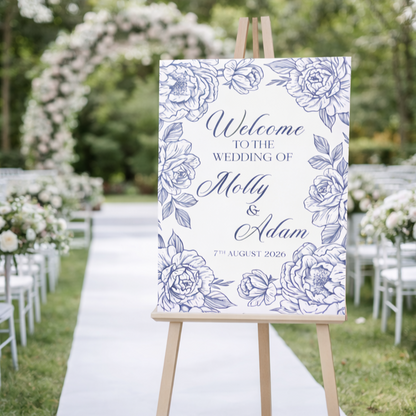 Wedding welcome sign with floral design on an easel outdoors