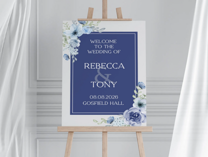 Wedding reception welcome sign with navy blue floral design on an easel 