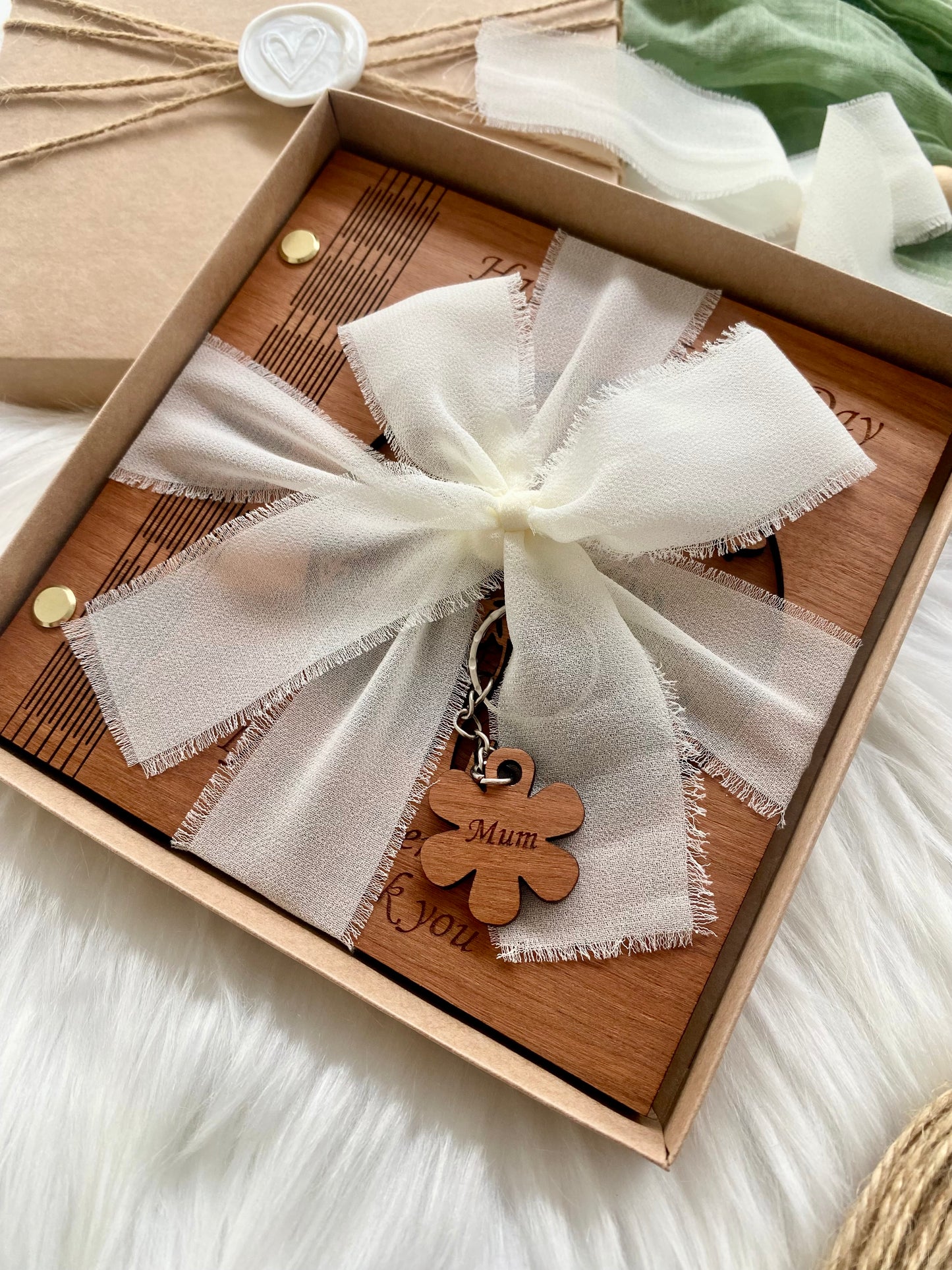 Gift box with a white ribbon wrapped card and wooden keychain with 'Mum' engraved