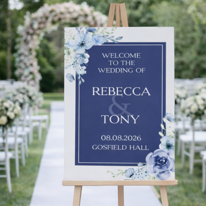 Wedding welcome sign with blue flowers on an easel at a wedding venue.