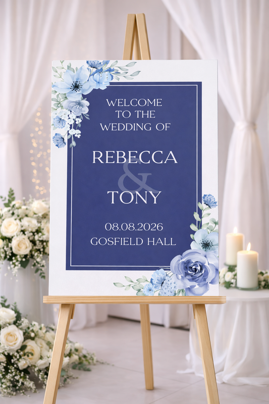 Navy Blue Wedding welcome sign with floral design on an easel, surrounded by flowers and candles.